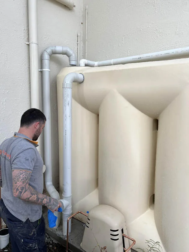 Tank and overflow pipework installed against the wall